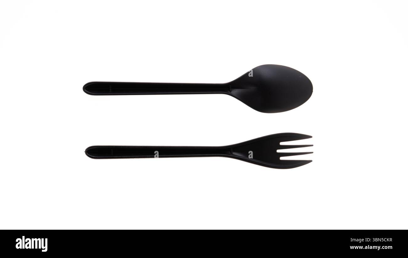 Cuillère noire et fourchette sur fond blanc Banque D'Images