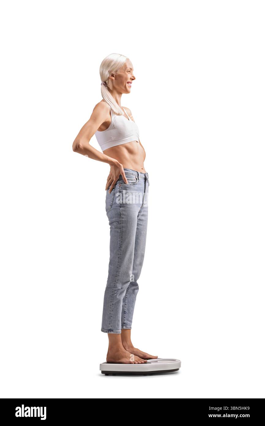 Femme maigre debout sur une balance isolée sur fond blanc Banque D'Images