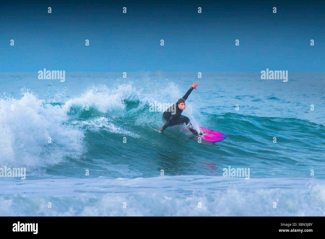 Un surfeur qui fait une vague à Fistral à Newquay, en Cornouailles, au Royaume-Uni. Banque D'Images