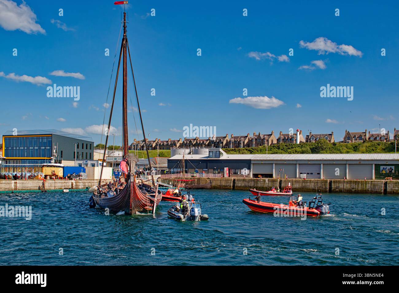 Le navire viking Draken Harald Harfagre et son équipage entrent dans Buckie Harbour Moray Scotland, guidé par plusieurs canots Banque D'Images