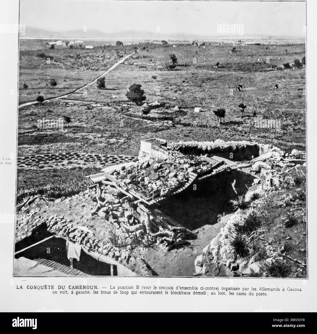 Photo de la première Guerre mondiale tirée de L’illustration, 1916, montrant la position défensive allemande « B » à Garoua, au nord du Cameroun. L'image capture un blockhaus en ruine entouré de fosses à loups (trous défensifs) pendant la campagne alliée au Kamerun allemand. Des huttes indigènes lointaines sont visibles. Cela marque un théâtre colonial de la première Guerre mondiale en Afrique. Banque D'Images
