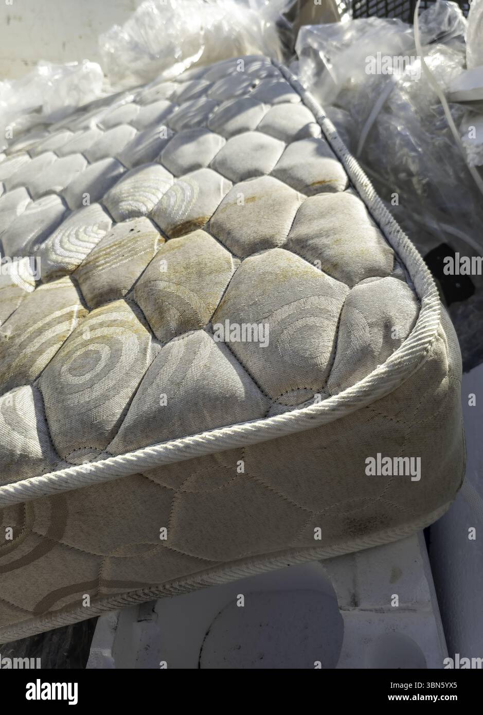 Détail du vieux matelas sale et endommagé dans la poubelle Banque D'Images