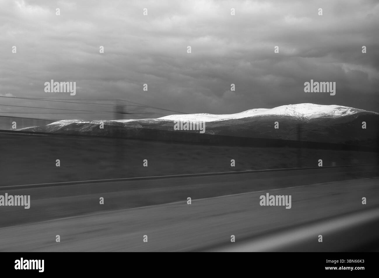 Les voies ferrées à la gare de Ségovie et les montagnes enneigées de la Sierra de Guadarrama en arrière-plan Banque D'Images