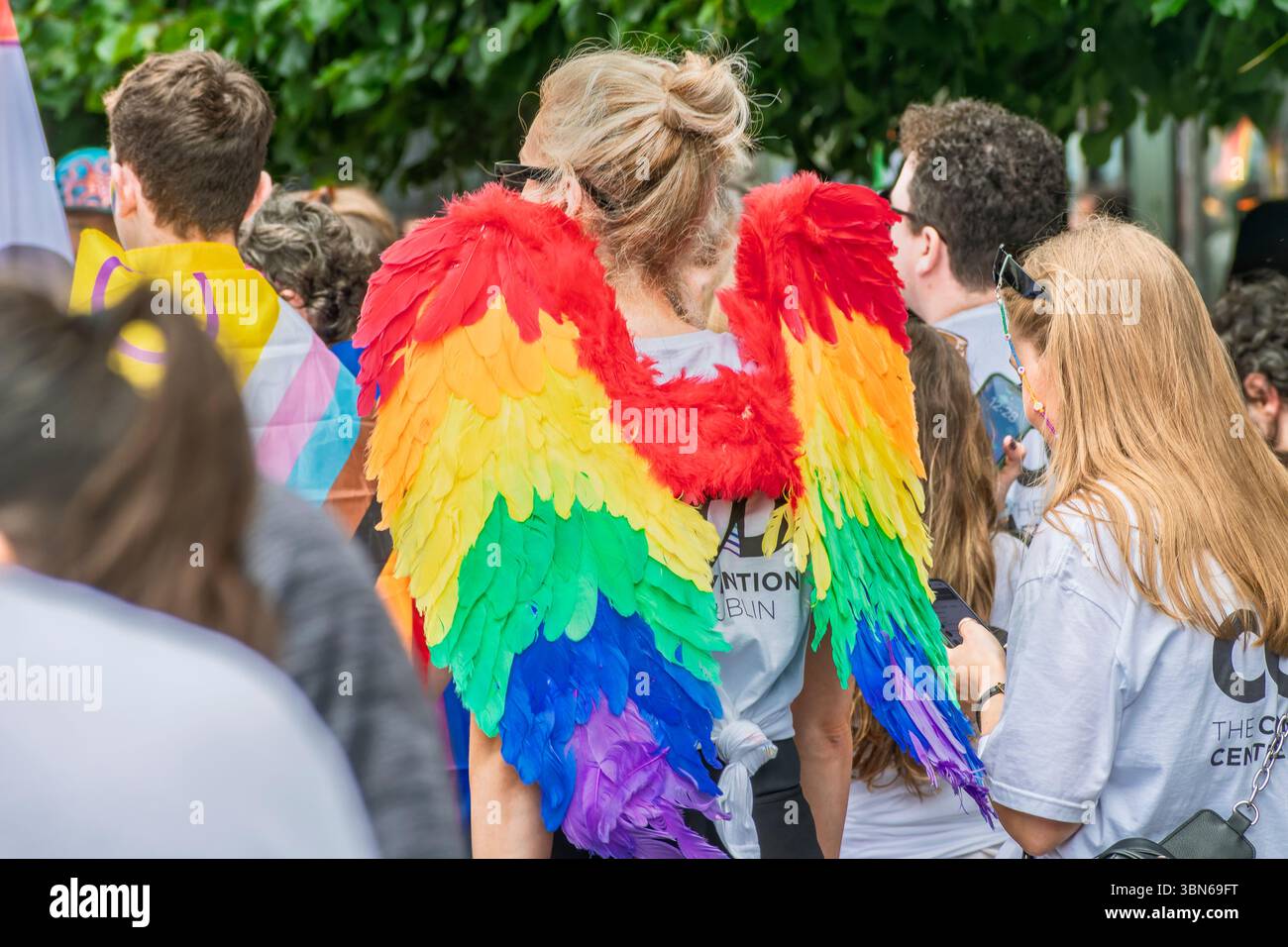 Une Lady Pride Marche dans des ailes d'ange arc-en-ciel vibrantes se tient parmi la foule à Dublin Pride Parade. 28 juin 2025 Banque D'Images