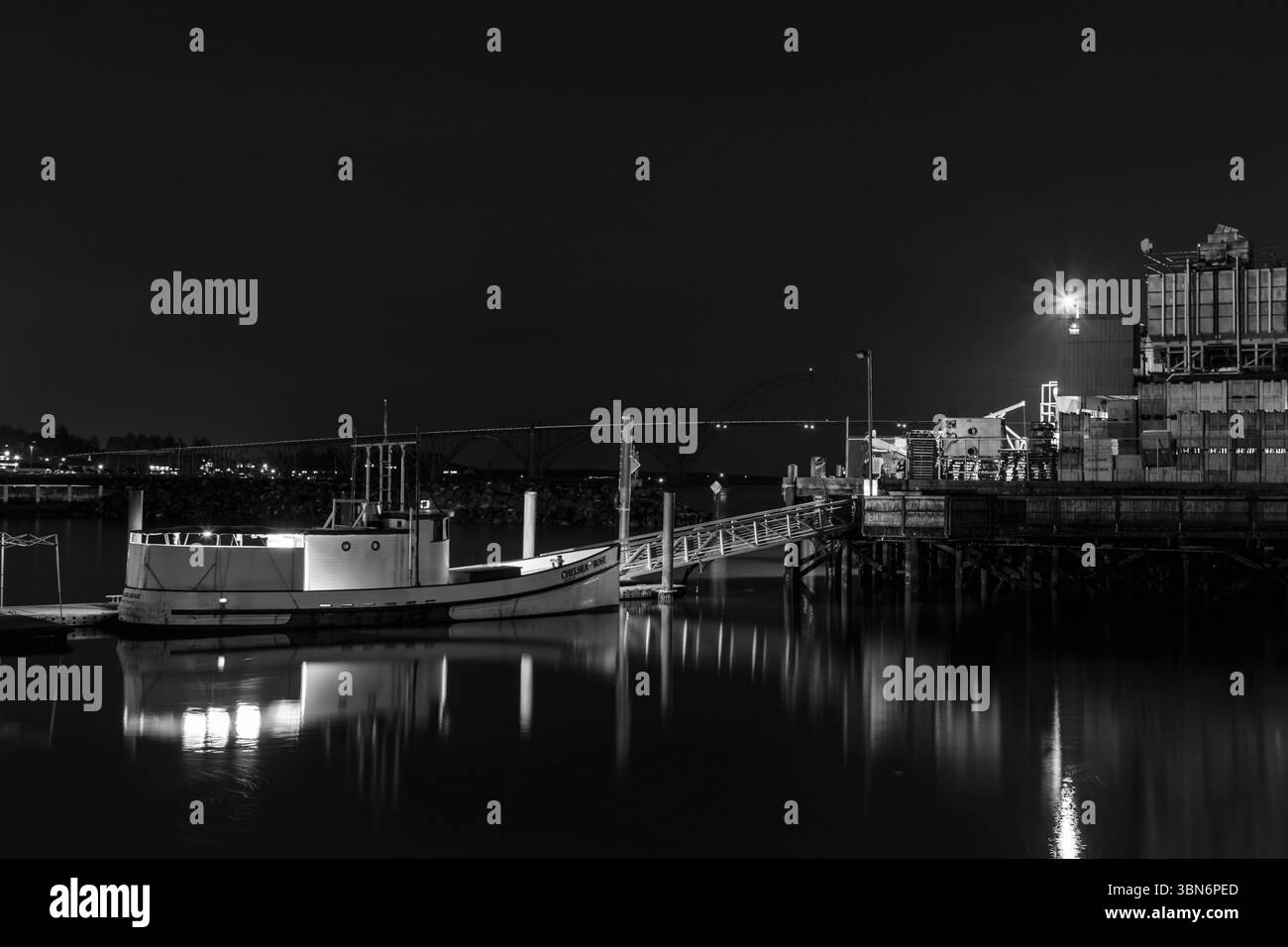 Newport, Oregon, USA - 10 mars 2017 : le bateau Chelsea Rose est amarré la nuit, reflétant dans l'eau. Banque D'Images