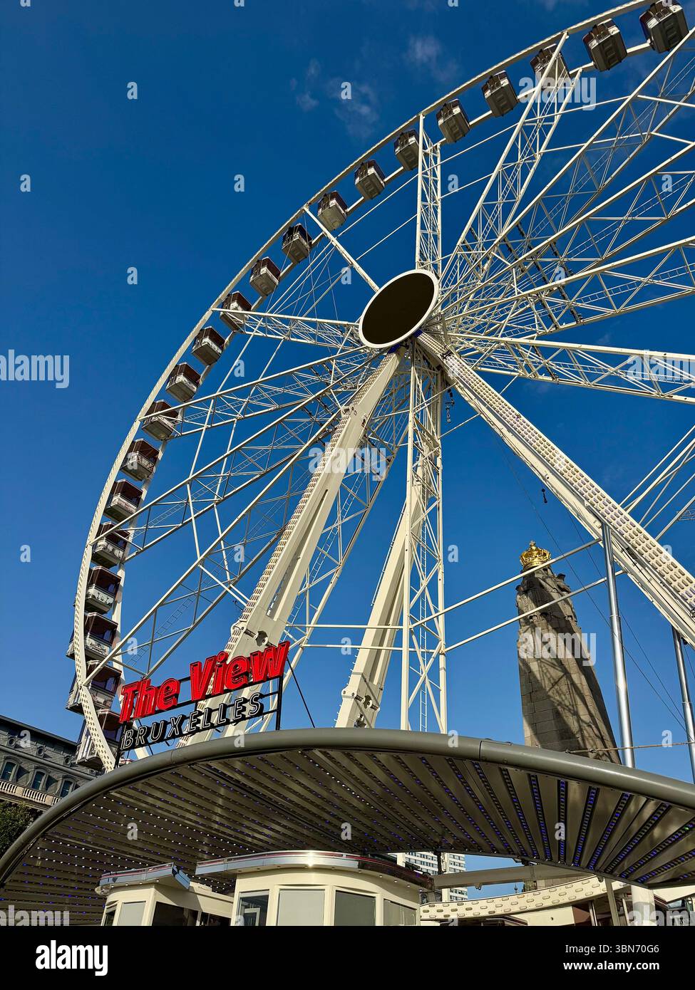 La roue View Brussels Ferris contre un ciel bleu clair avec la tour historique de l'Hôtel de ville en arrière-plan. Banque D'Images