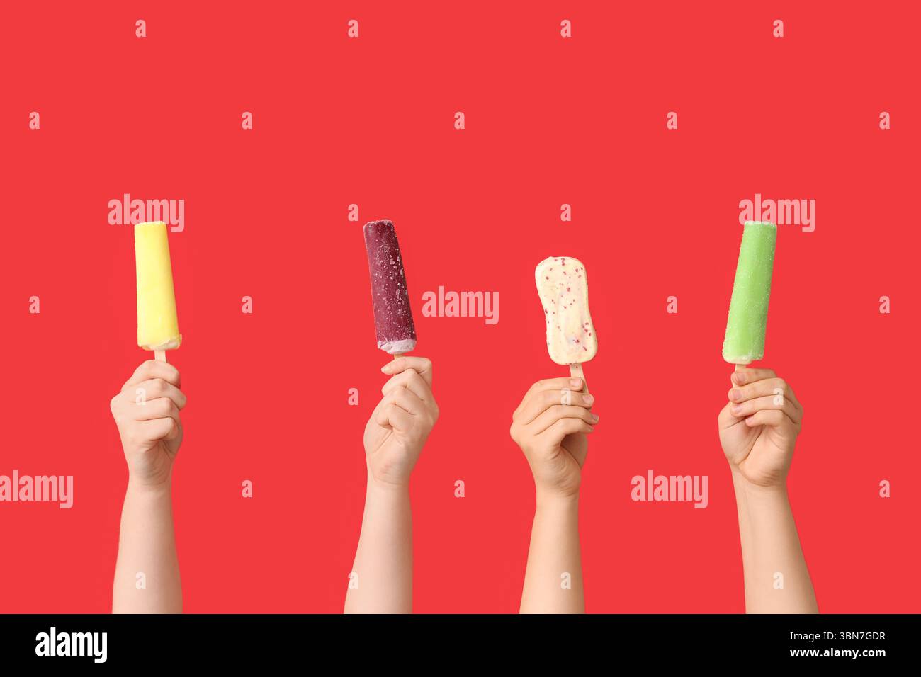 Mains féminines avec différentes glaces sucrées sur fond rouge Banque D'Images
