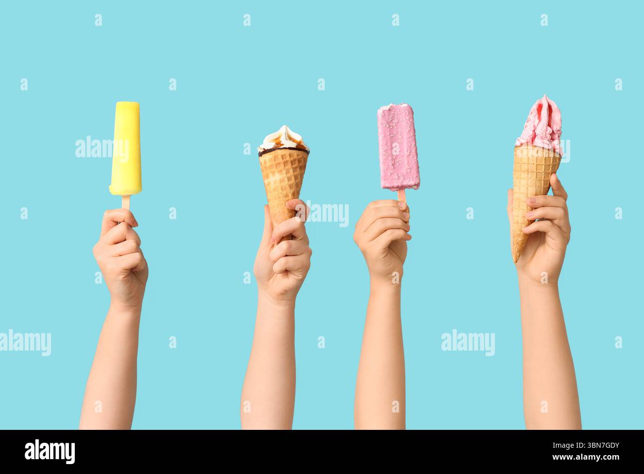 Mains féminines avec différentes glaces sucrées sur fond bleu Banque D'Images