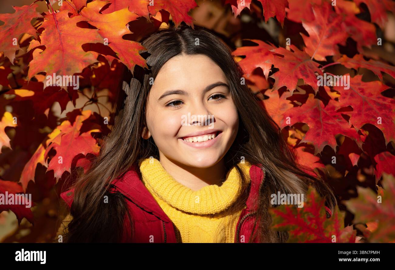 Visage de fille d'enfant d'automne sur fond de feuille d'automne. Automne enfant adolescente fille 12, 13, 14 ans portrait. fille heureuse debout aux feuilles rouges d'automne Banque D'Images