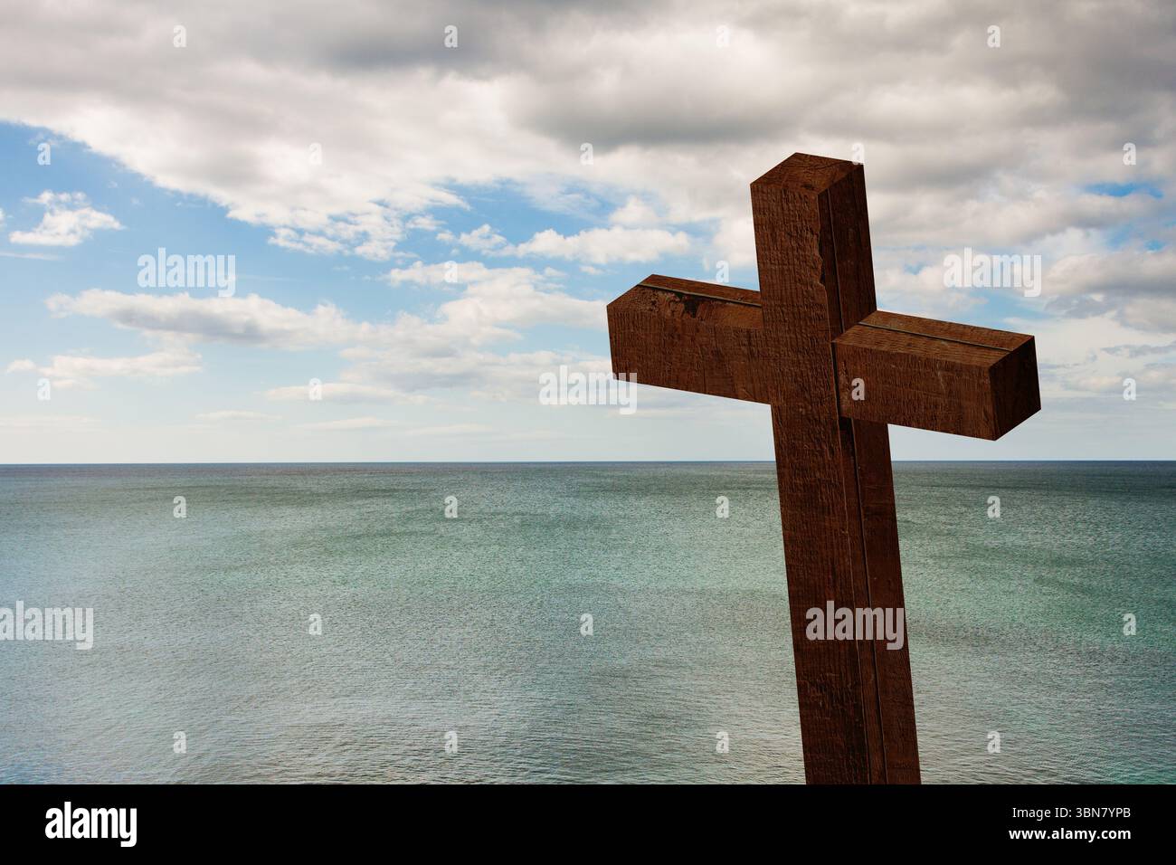 Croix en bois se tient au bord de la falaise dans un design plat, surplombant la mer turquoise sous le ciel nuageux Banque D'Images