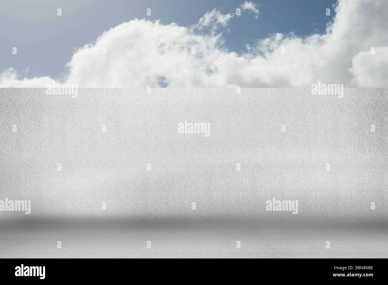 La conception plate montre le mur blanc blanc de stuc blanc vierge et le sol en béton sous le ciel bleu avec des nuages Banque D'Images