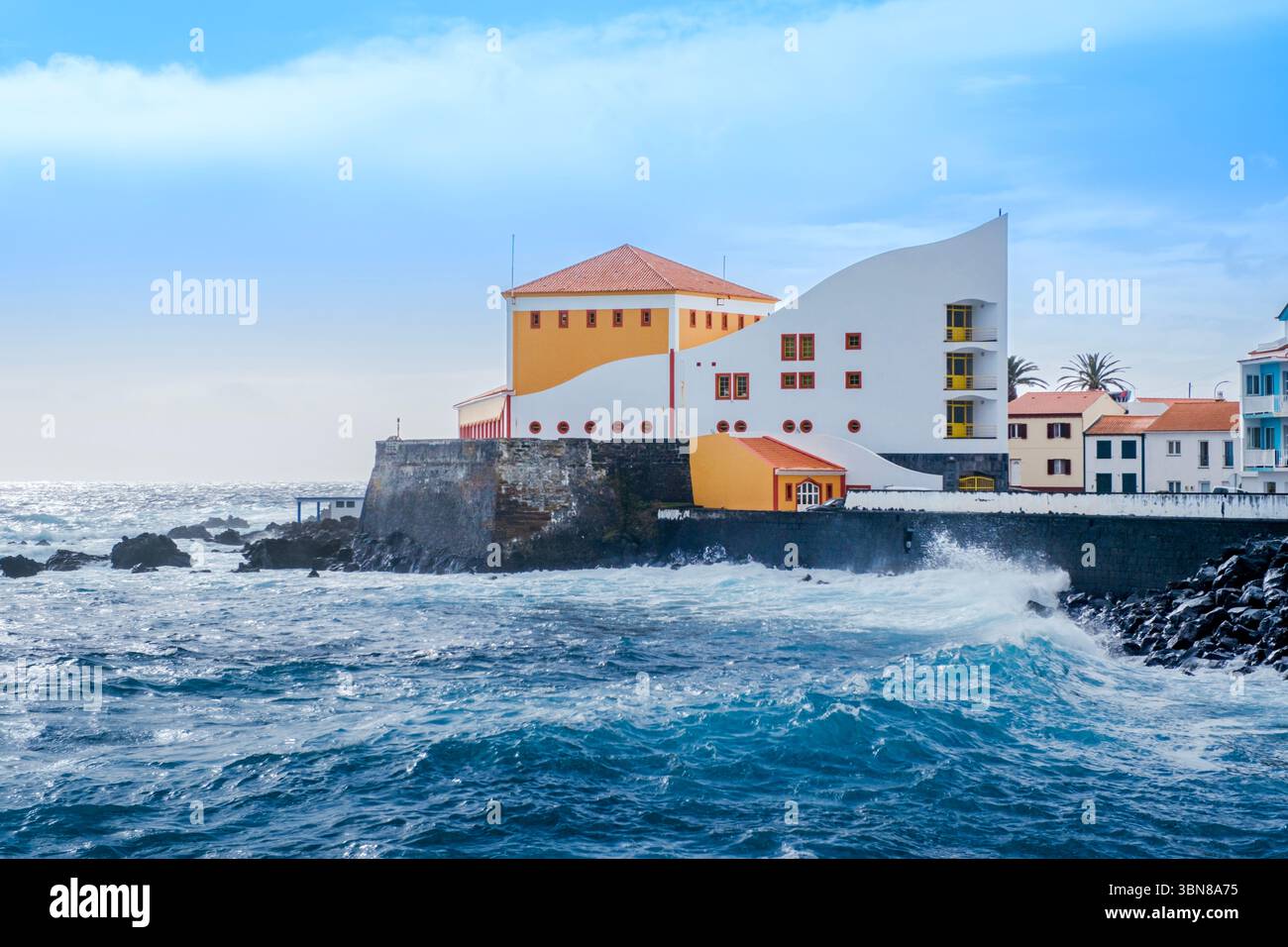 Spectaculaire bâtiment de théâtre en bord de mer avec murs de forteresse historiques face aux puissantes vagues de l'Atlantique à Velas Açores. Architecture côtière, lieu culturel Banque D'Images