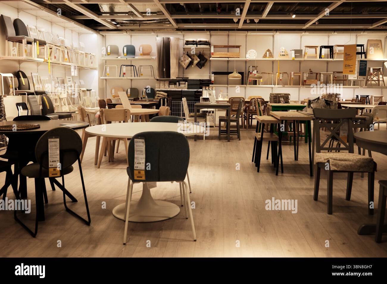 Présentoir IKEA pour salle à manger avec plusieurs tables et chaises de différentes couleurs et matériaux. Une section bien éclairée présentant une variété de sièges. Belgra Banque D'Images