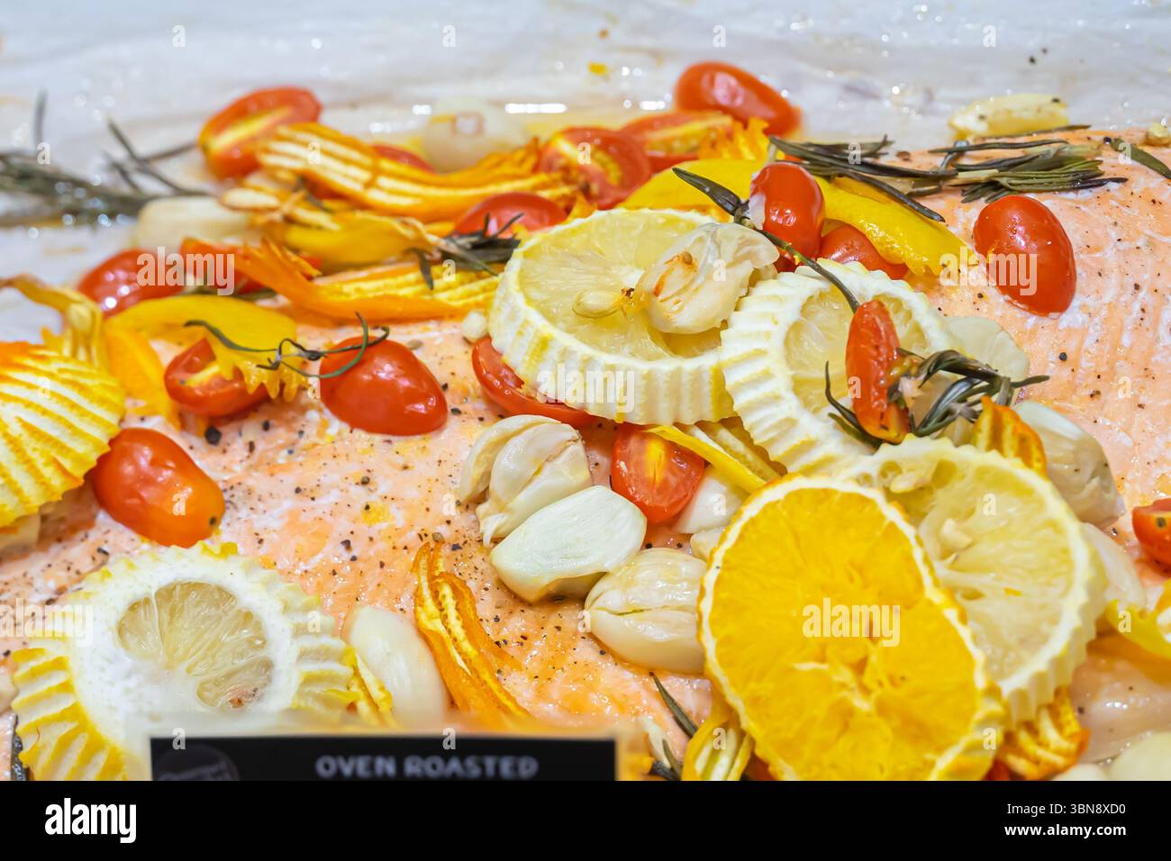 Un gros plan un plat de saumon avec des tranches de citron, tomates cerises, courges jaunes et gousses d'ail.marché gastronomique, Siam Paragon Banque D'Images