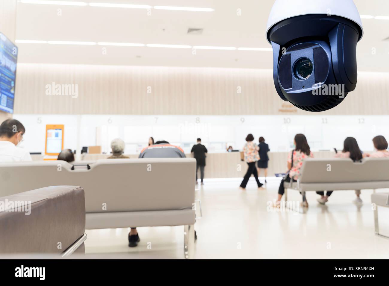 Caméra de vidéosurveillance surveillant la zone d'attente de l'hôpital où les patients sont assis et font la queue aux comptoirs de service. Sécurité et surveillance en public Banque D'Images