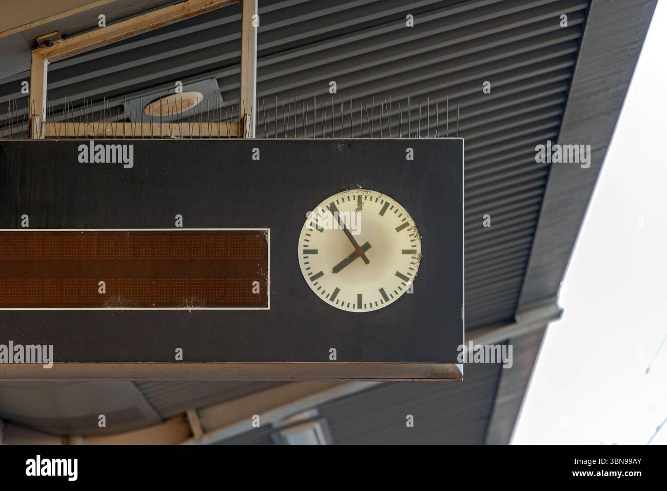 Horloge suspendue avec aiguilles anti-oiseaux à la plate-forme du terminal de la gare ferroviaire Banque D'Images