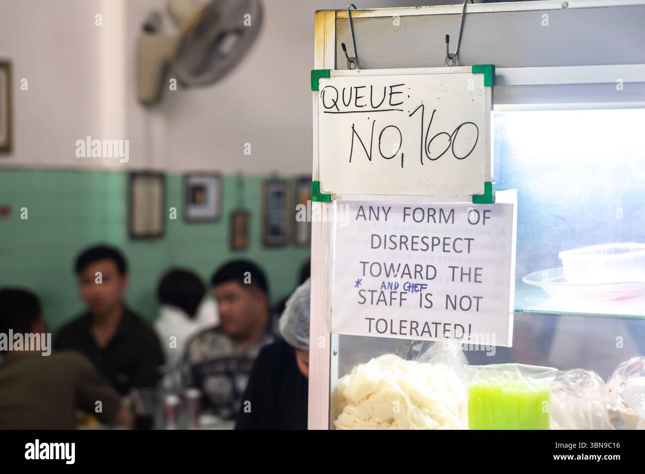 Un billet numéro 160 et un panneau avertissant contre le manque de respect envers le personnel et le chef dans un restaurant à Bangkok, Thaïlande Banque D'Images