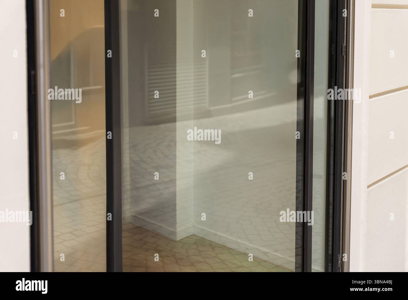 Vitrine vitrée avec intérieur vide et reflets de rue doux, parfait pour les annonces de location de magasin, les maquettes, ou les visuels de présentation d'affaires propres Banque D'Images