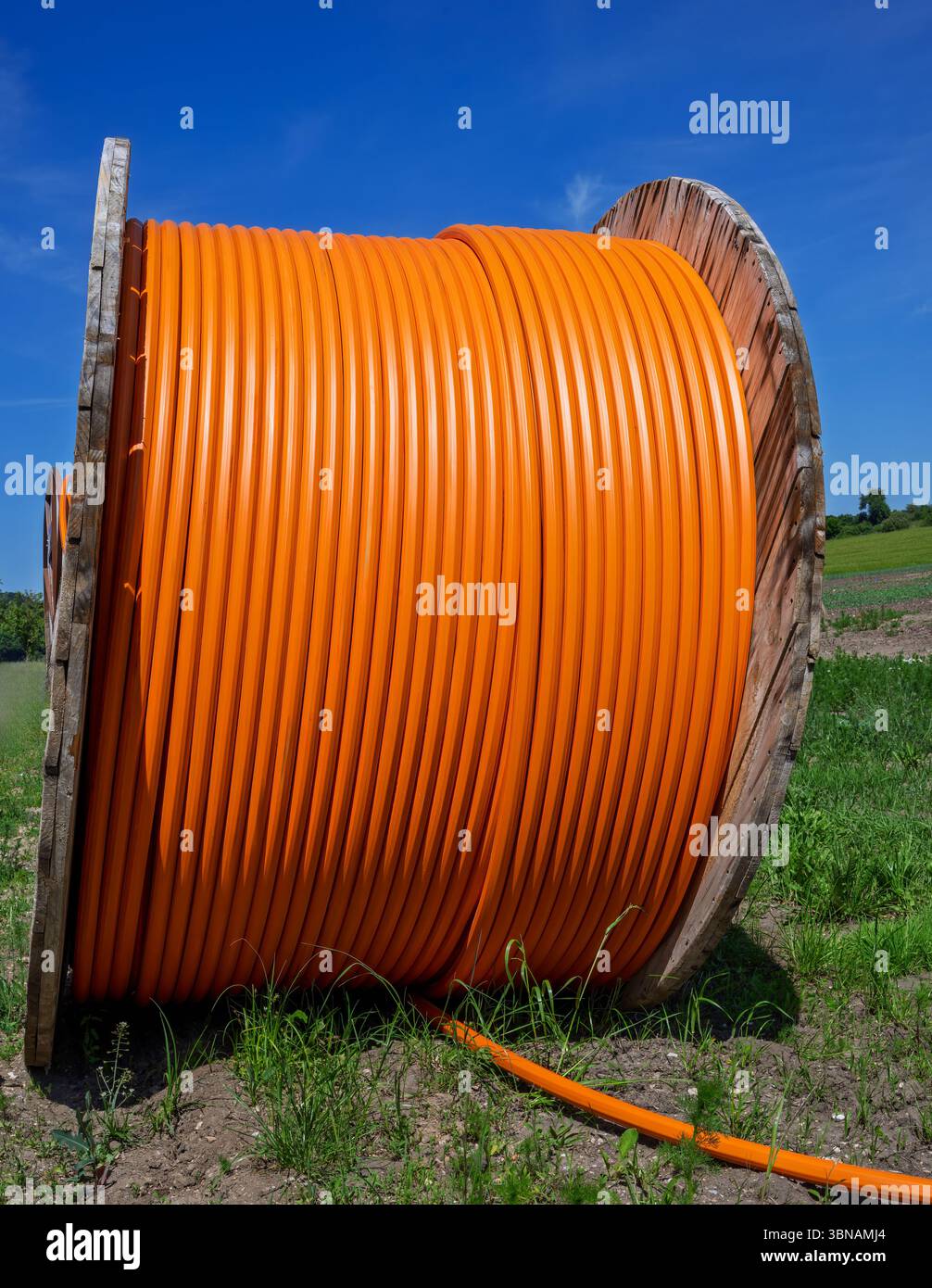 Site de construction avec un rouleau de câble à fibres optiques pour la communication internet haut débit numérique. Banque D'Images