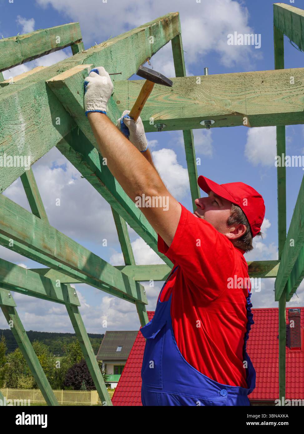 Carpenter la conduite d'un clou dans chambre rafter poutre ossature Banque D'Images
