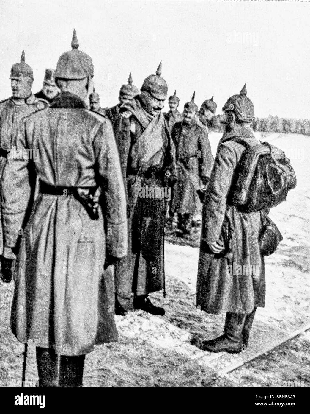 Le Kaiser Guillaume II rend visite aux troupes allemandes sur le front de l'est près de la rivière Strypa en Galice, décembre 1915. L'empereur allemand est vu parler à un soldat de Landwehr, flanqué d'officiers en casques de pickelhaube. Une scène enneigée de champ de bataille pendant la première Guerre mondiale, capturée par le photographe de guerre W. Braemer et publiée dans L’illustration. Banque D'Images