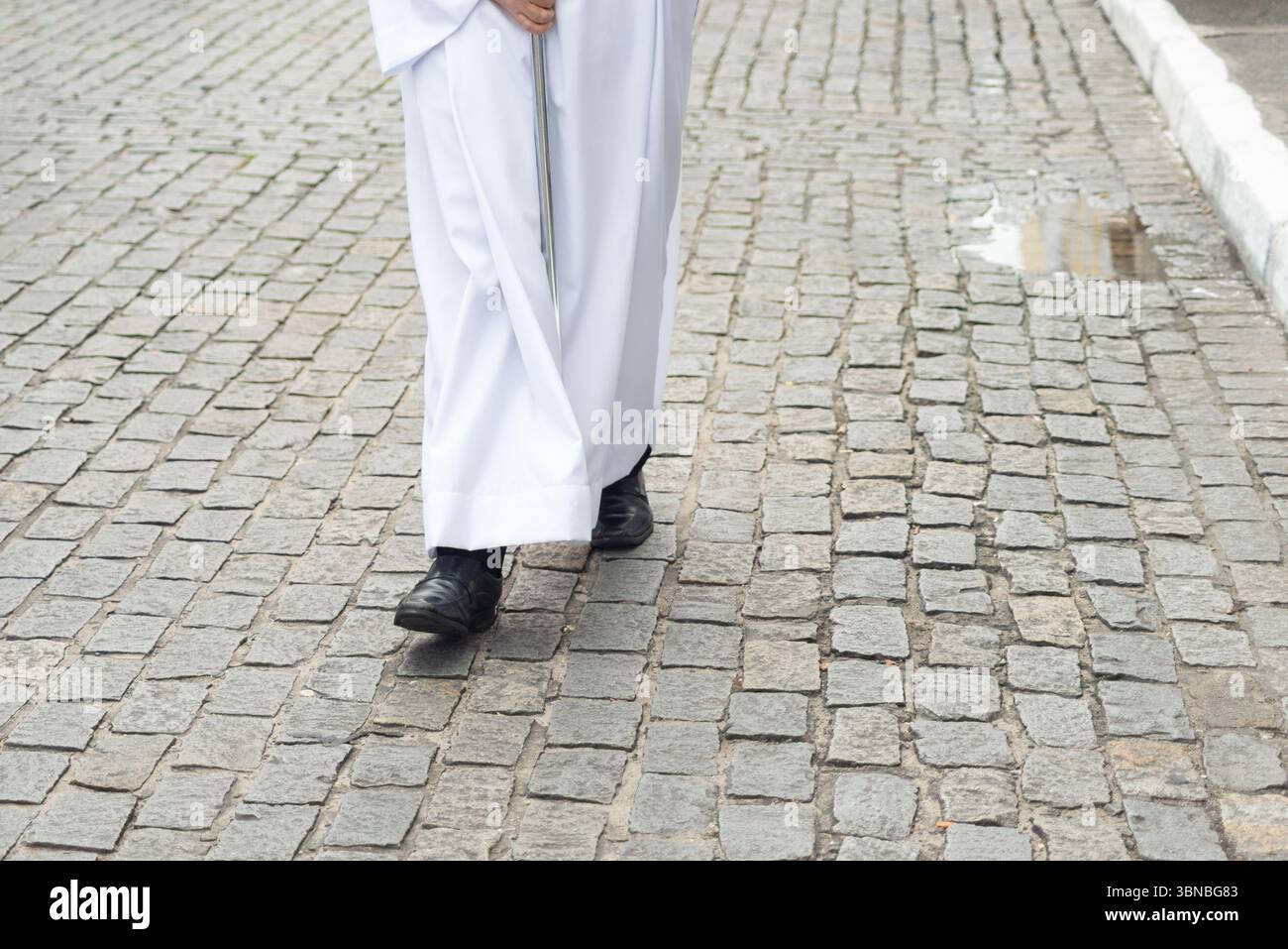 Photo en demi-longueur d'un adepte religieux non identifié marchant dans la rue portant des vêtements traditionnels. Salvador, Brésil Banque D'Images
