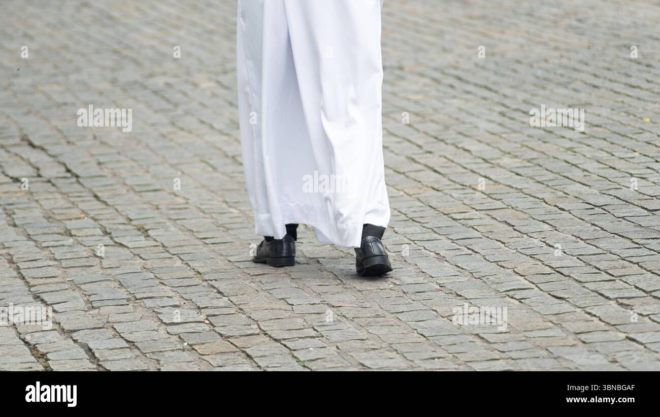 Photo en demi-longueur d'un adepte religieux non identifié marchant dans la rue portant des vêtements traditionnels. Salvador, Brésil Banque D'Images