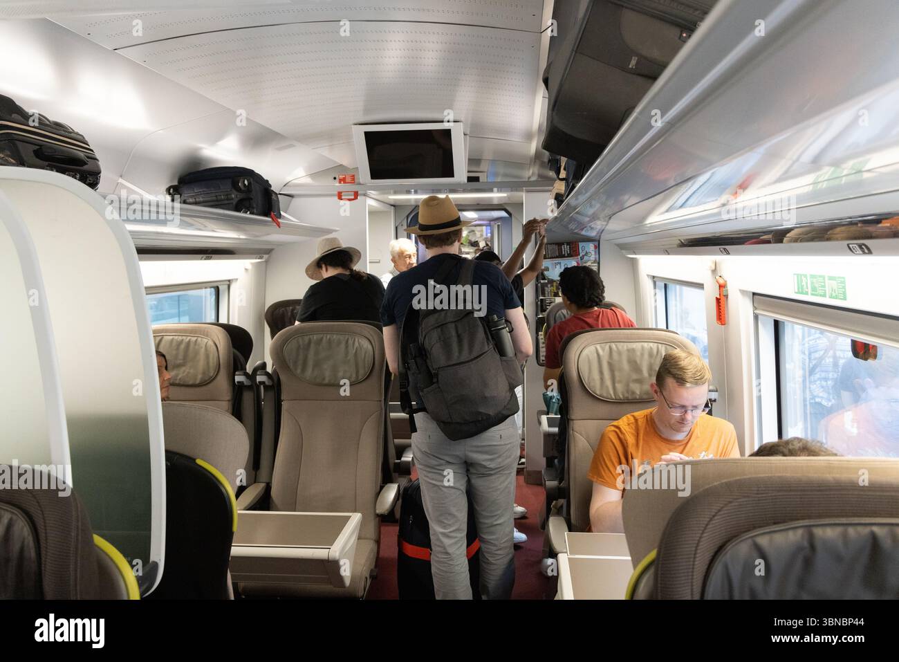 Intérieur du train Eurostar ; embarquement des passagers stockant leurs bagages et trouvant leurs sièges ; gare de St Pancras Londres Royaume-Uni Banque D'Images