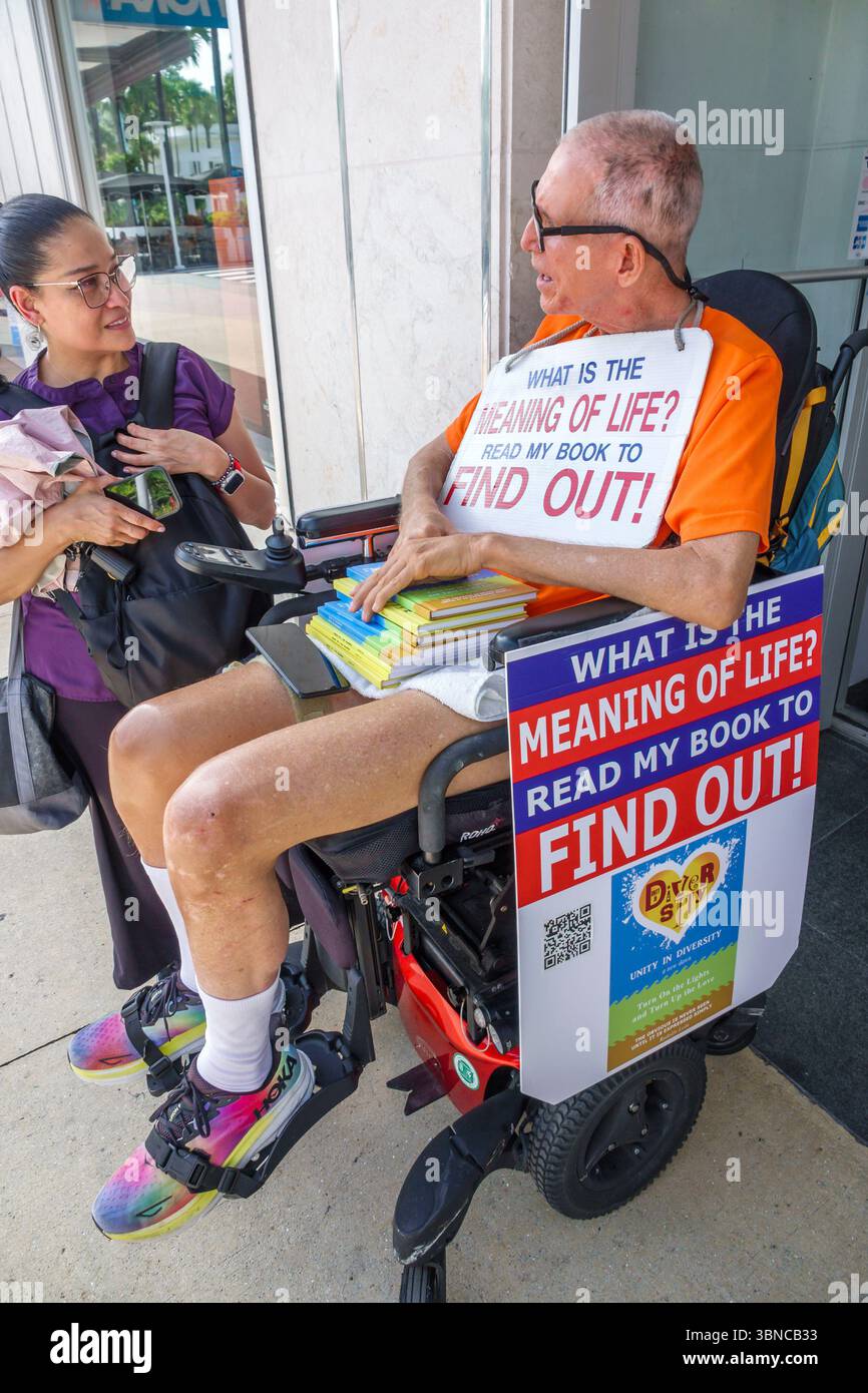 Miami Beach Floride, Lincoln Road centre commercial piétonnier, fauteuil roulant auto-édité handicapé auteur, homme masculin, femme hispanique parlant, adultes adultes, résident Banque D'Images