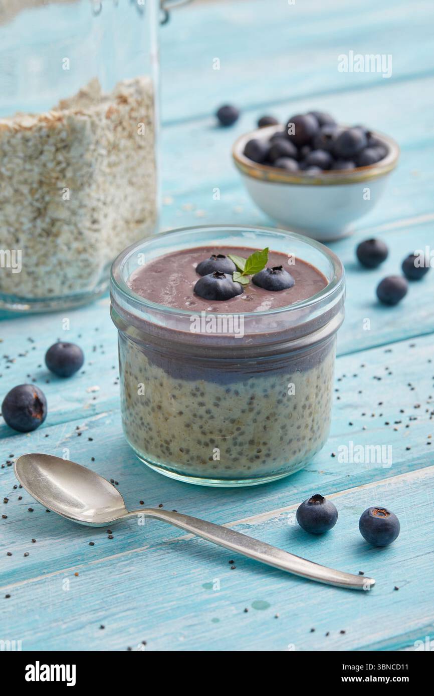 Avoine mélangée à de l'açaï et garnie de bleuets frais - un petit déjeuner fruité à base de plantes inspiré des superaliments brésiliens. Banque D'Images