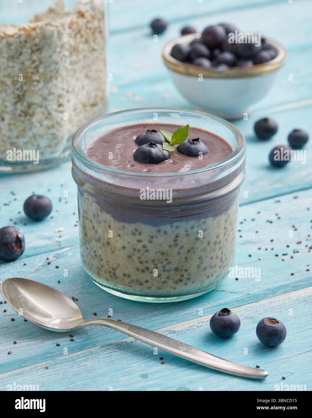 Avoine mélangée à de l'açaï et garnie de bleuets frais - un petit déjeuner fruité à base de plantes inspiré des superaliments brésiliens. Banque D'Images