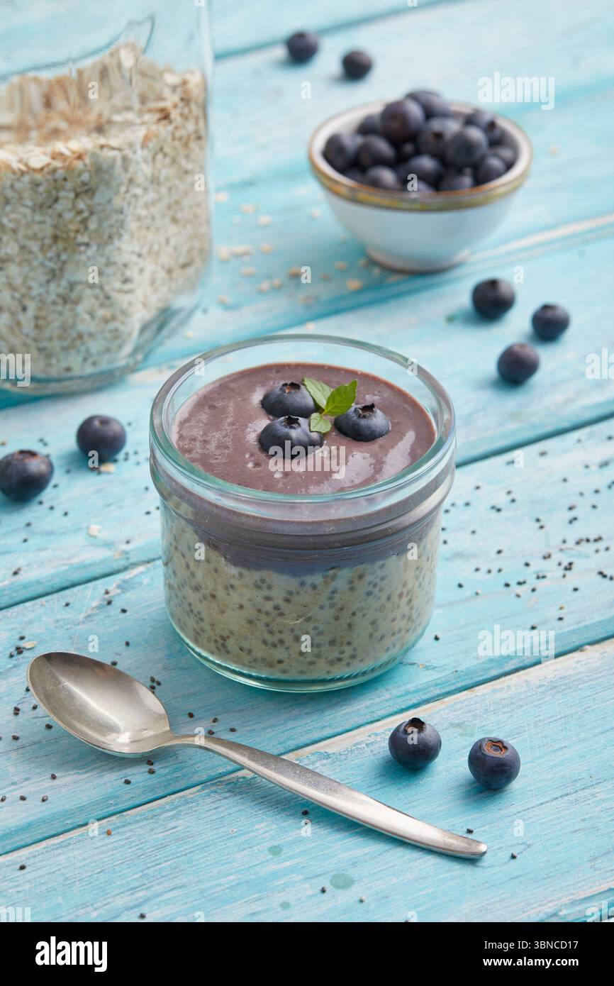 Avoine mélangée à de l'açaï et garnie de bleuets frais - un petit déjeuner fruité à base de plantes inspiré des superaliments brésiliens. Banque D'Images