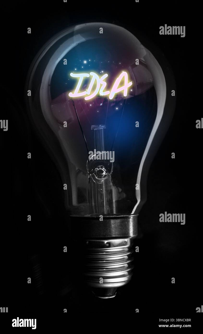 Montrant le filament d'IDÉE incandescent dans l'ampoule à incandescence soulignant la base de la vis, particules sur le vide noir Banque D'Images