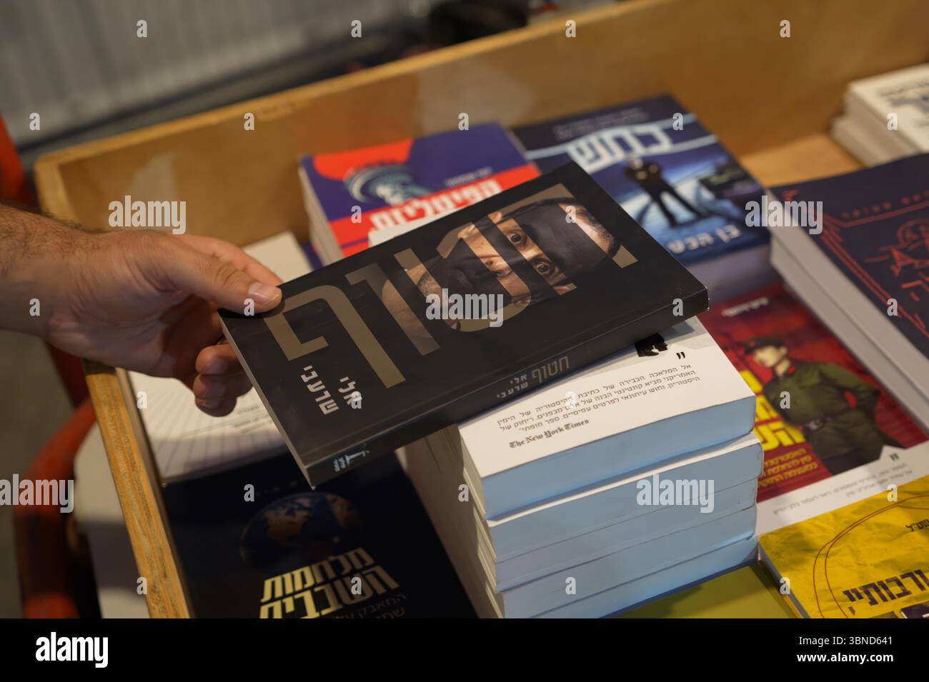 JÉRUSALEM - 1er JUILLET : une personne achète une copie de 'otage' écrit par Eli Sharabi, un otage israélien retourné qui détaille les 491 jours que Sharabi a été retenu captif à Gaza par le Hamas lors d'une foire du livre en plein air pendant la semaine du livre hébreu consacrée à la littérature hébraïque, le 1er juillet 2025 à Jérusalem. Israël Banque D'Images JÉRUSALEM - 1er JUILLET : une personne achète une copie de 'otage' écrit par Eli Sharabi, un otage israélien retourné qui détaille les 491 jours que Sharabi a été retenu captif à Gaza par le Hamas lors d'une foire du livre en plein air pendant la semaine du livre hébreu consacrée à la littérature hébraïque, le 1er juillet 2025 à Jérusalem. Israël Banque D'Images