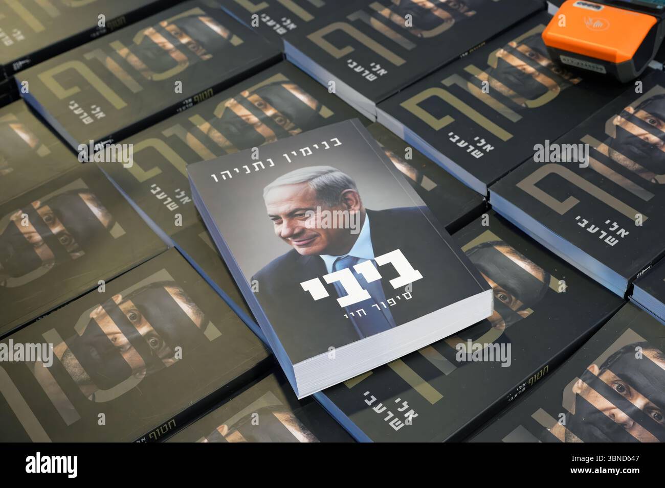 JÉRUSALEM - 1er JUILLET : le livre de mémoire 'Bibi, l'histoire de ma vie' du premier ministre Benjamin Netanyahu est affiché sur des copies de 'otage' écrit par Eli Sharabi, un otage israélien retourné qui détaille les 491 jours que Sharabi a été retenu captif à Gaza par le Hamas, lors d'une foire du livre en plein air pendant la semaine du livre hébreu consacrée à la littérature hébraïque, au milieu du cessez-le feu avec l'Iran et de la guerre à Gaza le 1er juillet 2025 à Jérusalem. Israël Banque D'Images JÉRUSALEM - 1er JUILLET : le livre de mémoire 'Bibi, l'histoire de ma vie' du premier ministre Benjamin Netanyahu est affiché sur des copies de 'otage' écrit par Eli Sharabi, un otage israélien retourné qui détaille les 491 jours que Sharabi a été retenu captif à Gaza par le Hamas, lors d'une foire du livre en plein air pendant la semaine du livre hébreu consacrée à la littérature hébraïque, au milieu du cessez-le feu avec l'Iran et de la guerre à Gaza le 1er juillet 2025 à Jérusalem. Israël Banque D'Images