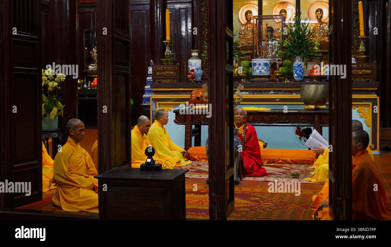 Moines bouddhistes méditant et chantant à l'intérieur de la pagode Thien Mu à Hue, Vietnam Banque D'Images
