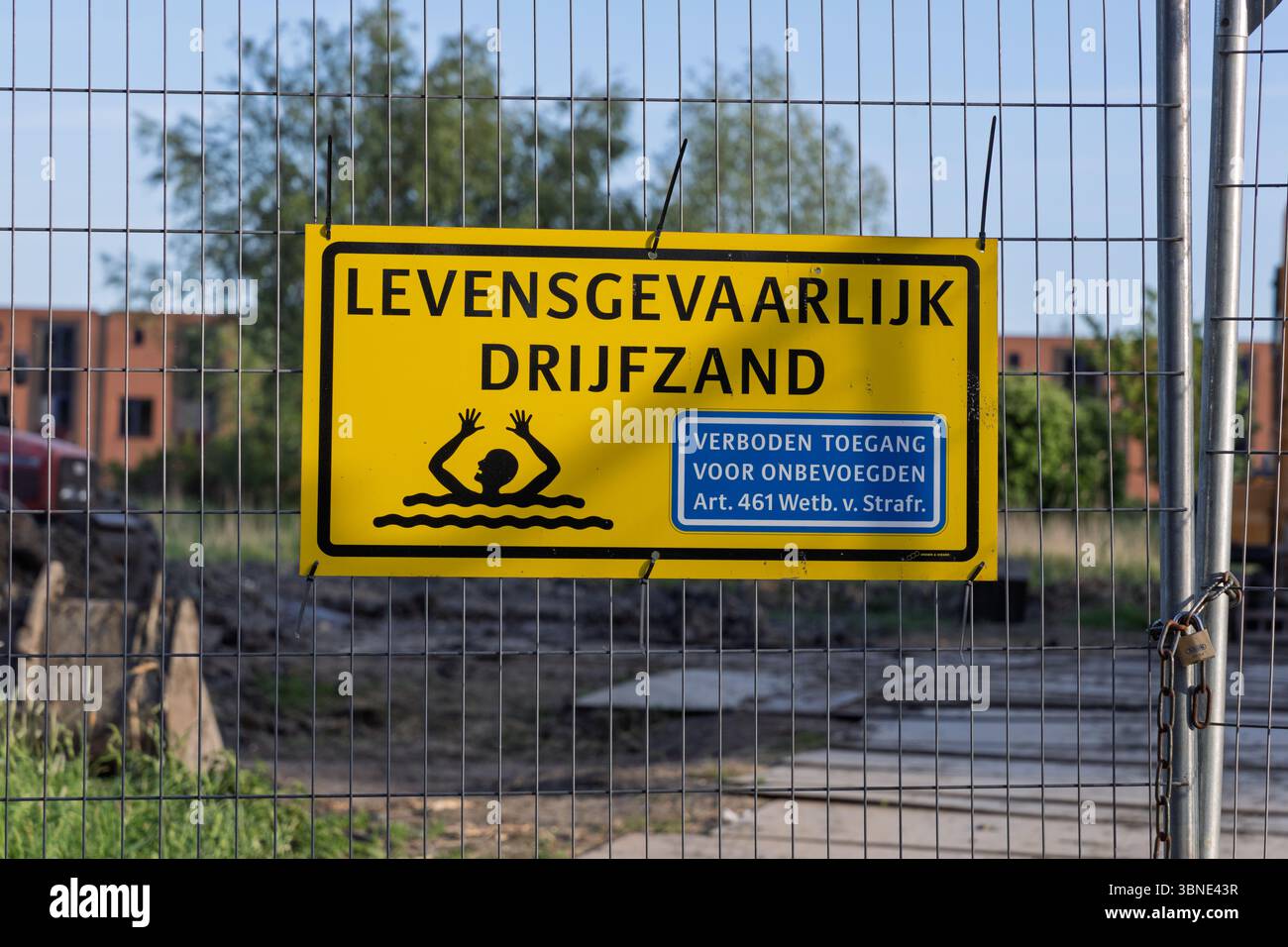 Un panneau hollandais jaune vif avertit de drijfzand 'létal Quicksand' et d'accès interdit, monté sur une clôture, soulignant le danger et la sécurité. Banque D'Images