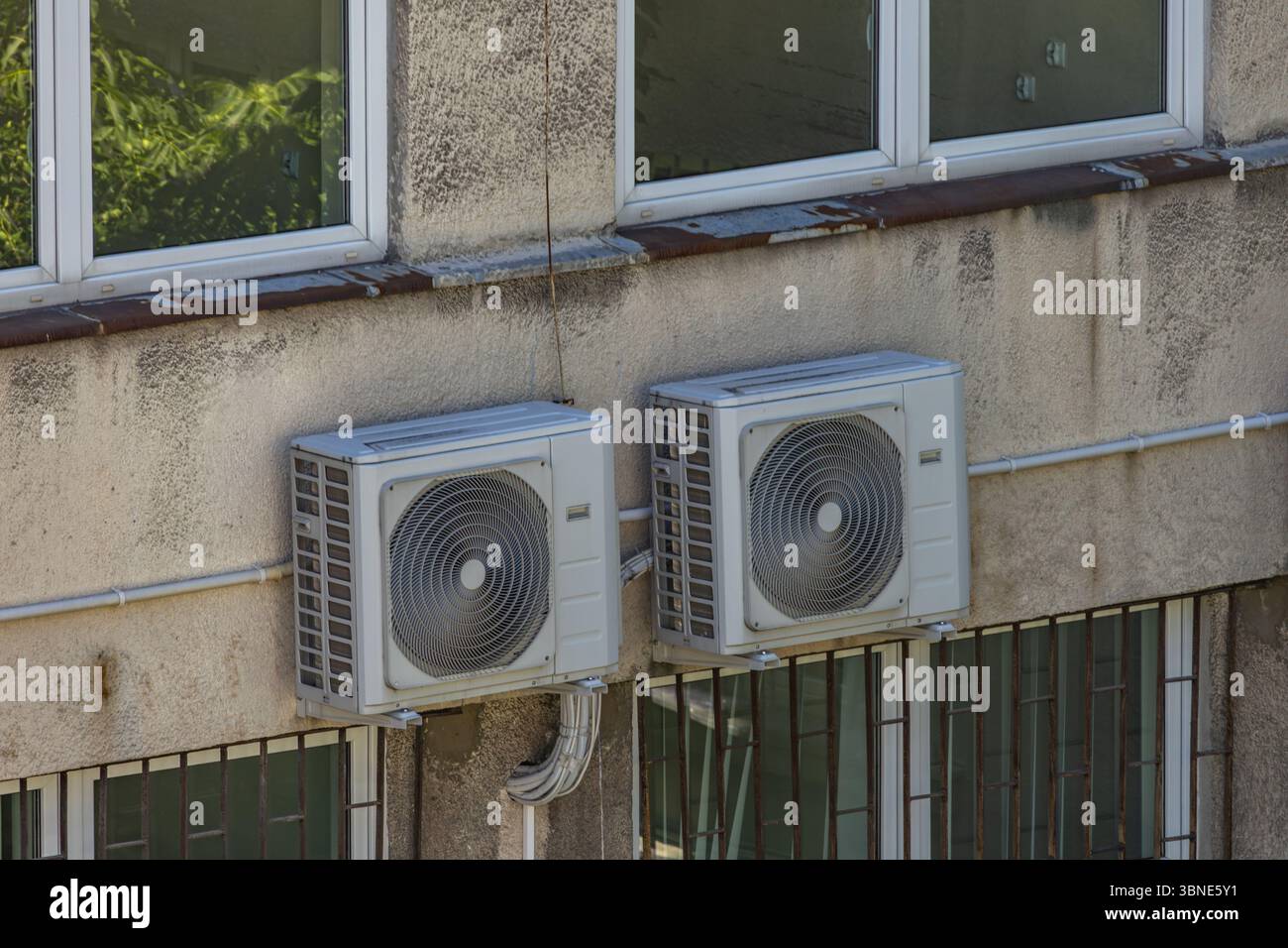 Vieux climatiseurs endommagés nécessitant un entretien et fongicides accrochés au mur extérieur d'un bâtiment d'utilité publique, panne de climatisation, Banque D'Images