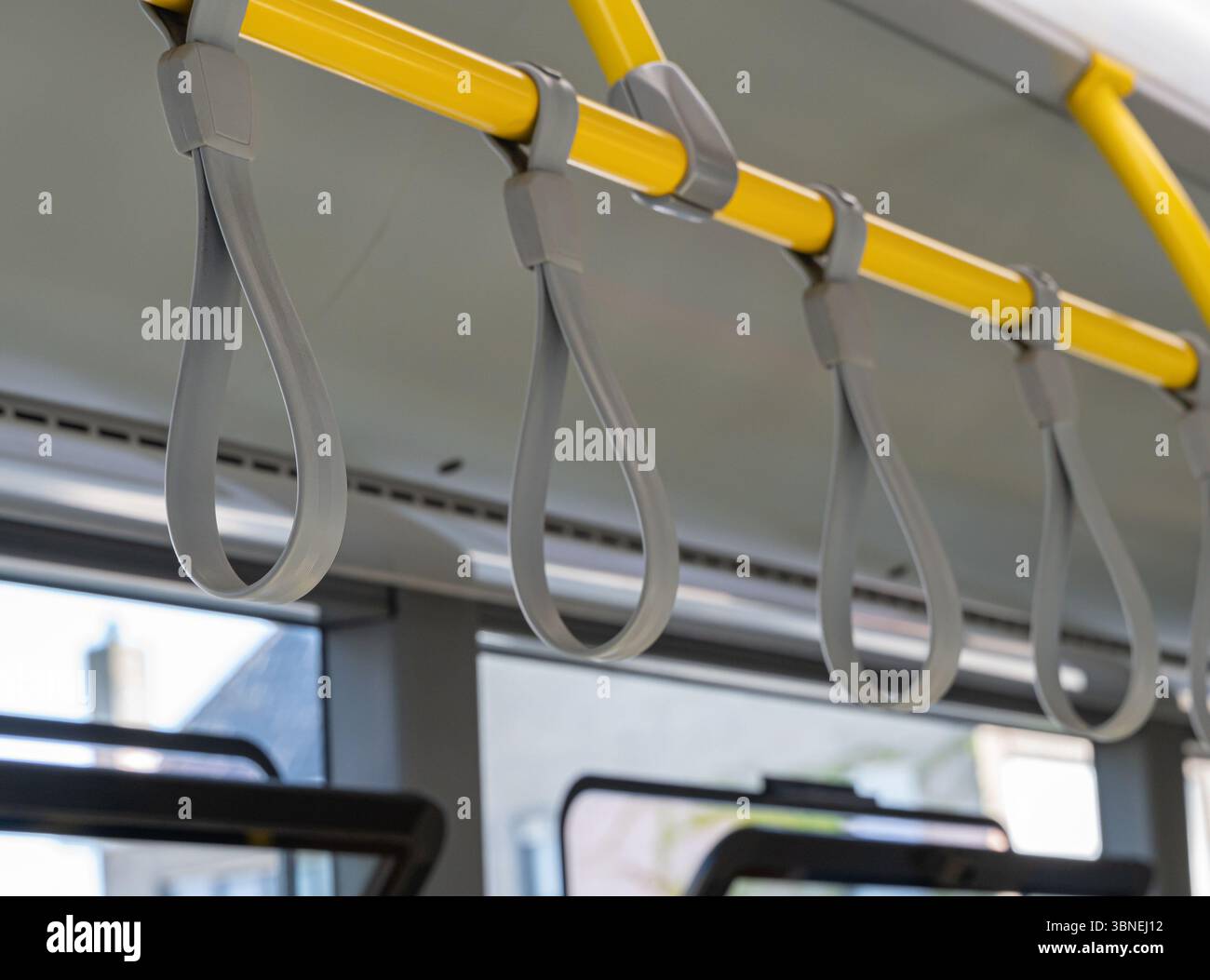 Gros plan de sangles de suspension jaunes robustes dans les transports publics pour la sécurité et le confort des navetteurs pendant les trajets Banque D'Images