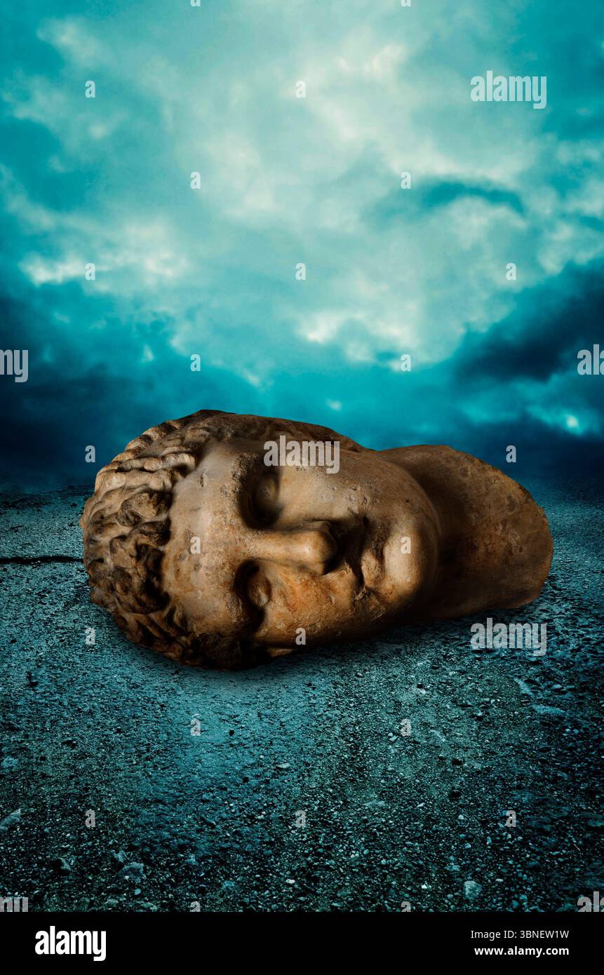 ancienne statue romaine géante sculpture tête sur une terre désertique Banque D'Images