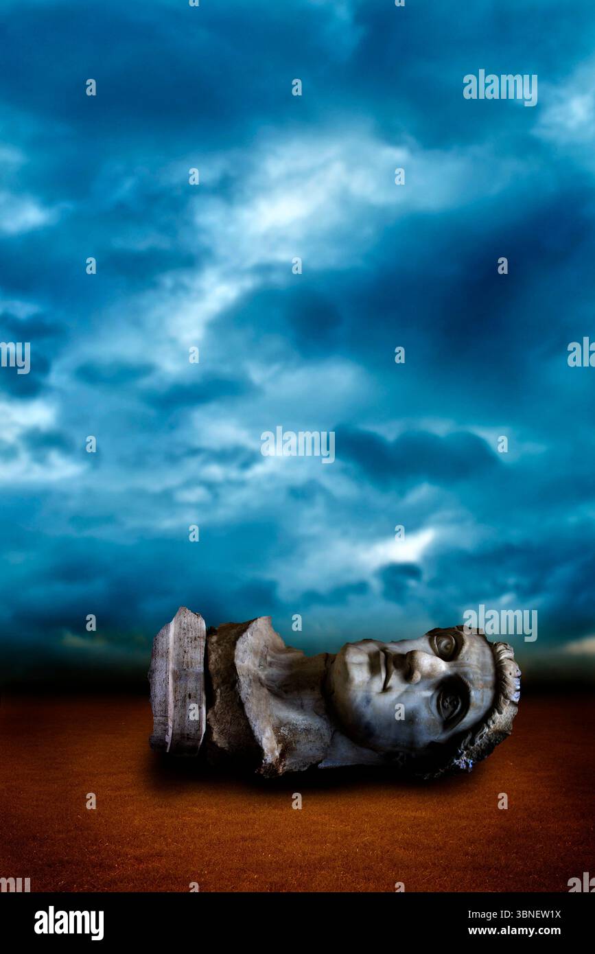 ancienne statue romaine géante sculpture tête sur une terre désertique Banque D'Images