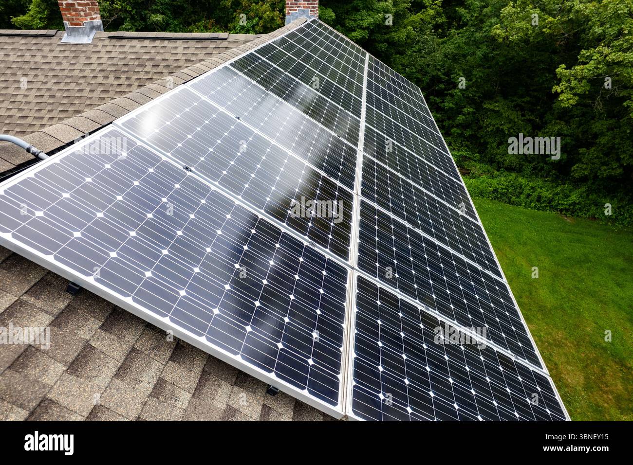 Vue aérienne d'un toit résidentiel moderne avec des panneaux solaires installés le long de la ligne de toit. Banque D'Images