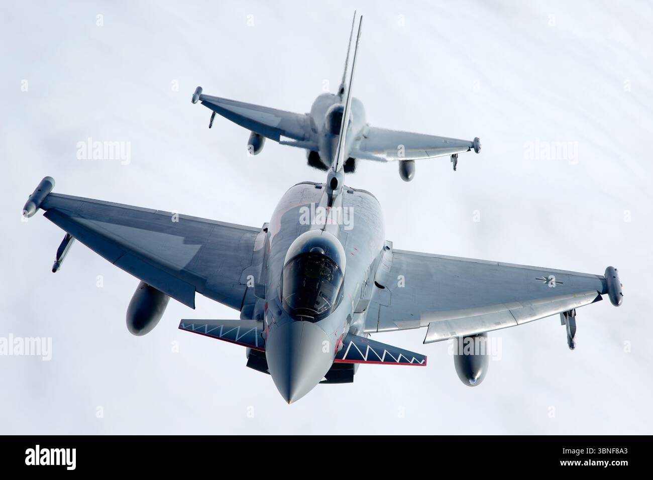 Deux avions Luftwaffe Eurofighter EF‑2000 Typhoon S, y compris le vol. 30+90 (série GS069) et 30+33 (série GS021), volent en formation au large de Wittmundhafen. Les deux sports centenaires de peintures commémoratives célébrant 100 ans de patrimoine unitaire. Les chasseurs canard-delta bimoteurs font preuve d'un positionnement en vol coordonné et d'une conception multirôle moderne. Banque D'Images
