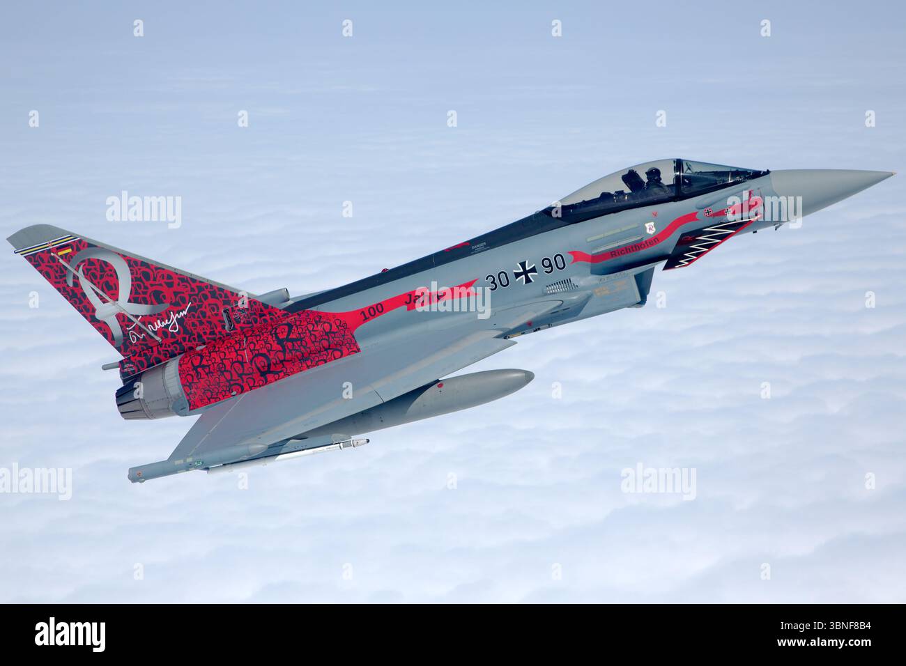 Single Luftwaffe Eurofighter EF‑2000 Typhoon S reg. 30+90 (GS069) vole en solo au large de Wittmundhafen, affichant une livrée de peinture commémorative du centenaire marquant 100 ans d'histoire de l'escadron. Le chasseur canard‑delta bimoteur présente son profil aérodynamique propre et sa capacité de mission multirôle moderne. Banque D'Images