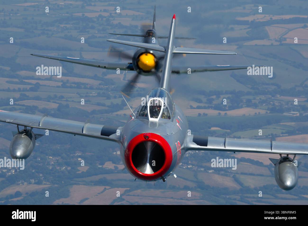 Le Hawker Sea Fury T20S du Royal Navy Historic Flight, immatriculé VX281, dirige une formation avec le PZL-Mielec Lim-2 (MiG-15) de l'armée de l'air soviétique, immatriculé N104CJ. Ces deux avions emblématiques, l’un du côté britannique et l’autre du côté soviétique, représentent l’évolution des avions de combat navals et aériens dans la période de l’après-guerre. Banque D'Images