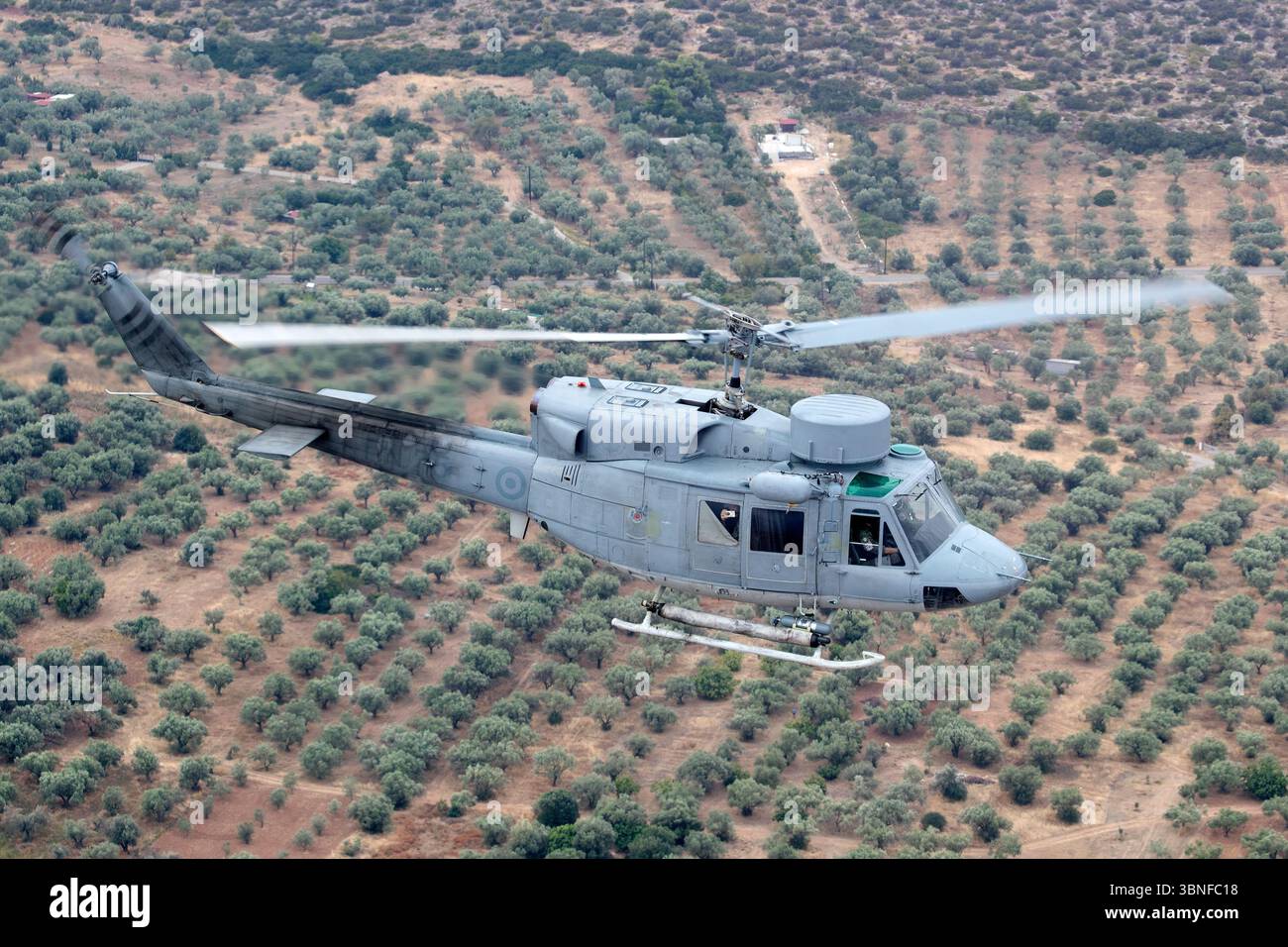 Un hélicoptère Agusta AB‑212ASW de la marine hellénique, immatriculé PN25, est capturé en vol au cours d’une mission photo air‑air au-dessus de la mer Égée. La variante maritime bimoteur du Bell 212 est équipée d'un sonar plongeant, d'un radar de recherche de surface et de torpilles légères pour la guerre anti-sous-marine. Banque D'Images