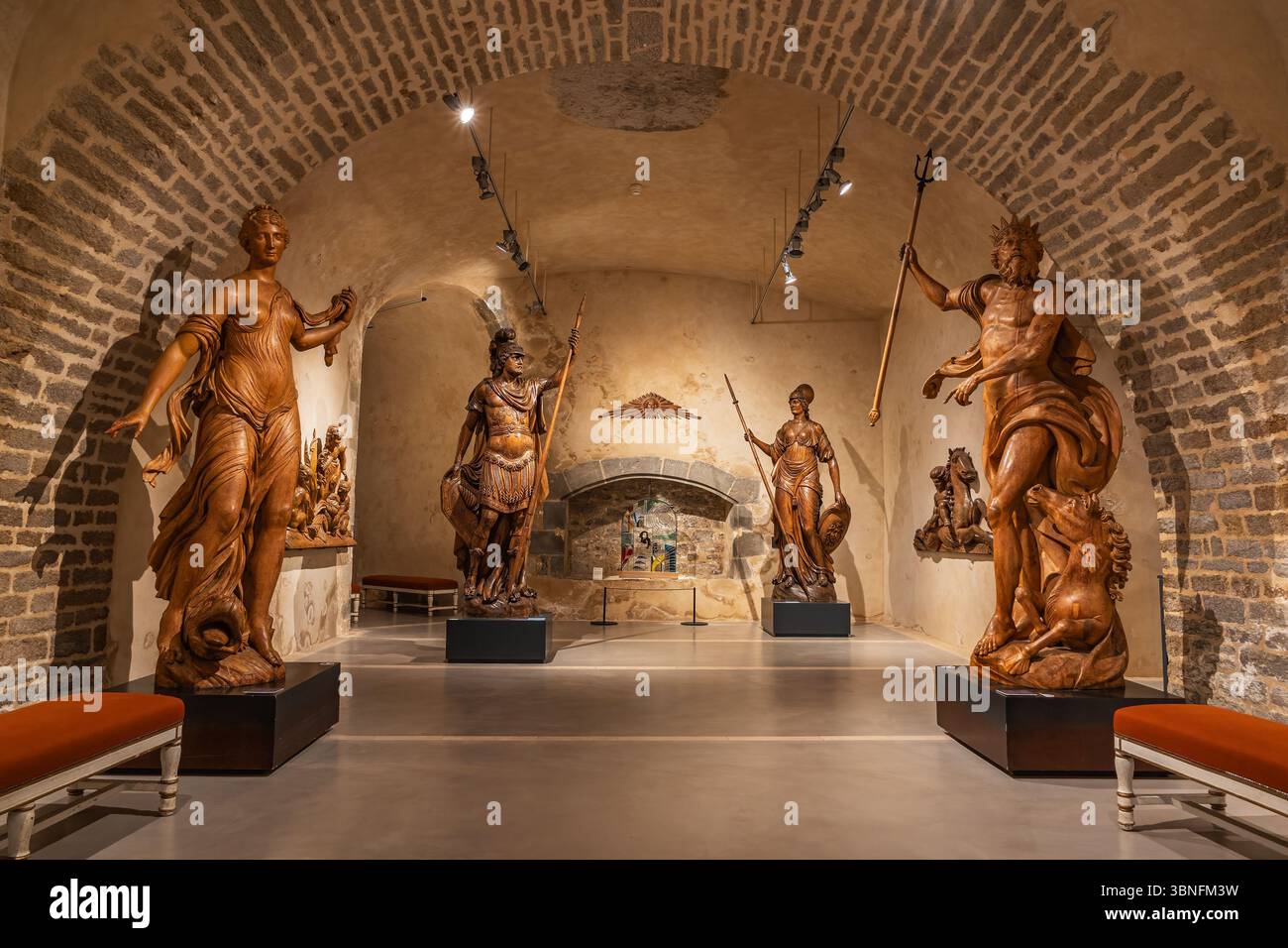 Collection de figures de proue de navires en bois du XVIIIe au XIXe siècle, dont Neptune et Minerva, exposées dans une salle d'exposition en pierre voûtée à la Marine Muse de Brest Banque D'Images