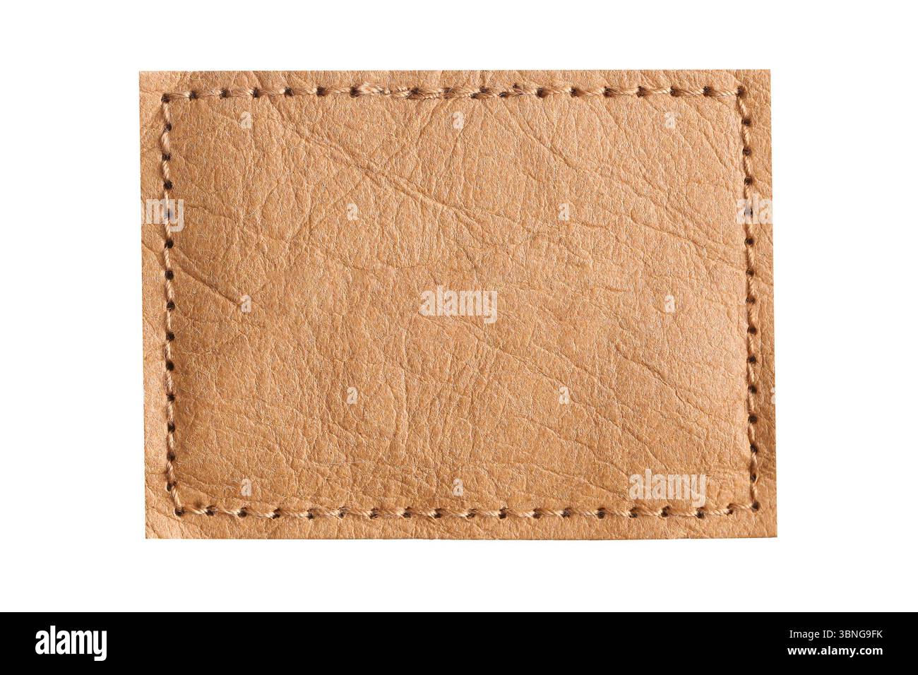 Patch en cuir marron avec des points de suture. Étiquette sur fond de tissu. ELEMENT de détail de VETEMENT. Gros plan de la balise rectangulaire vierge. Surface texturée pour brandin Banque D'Images