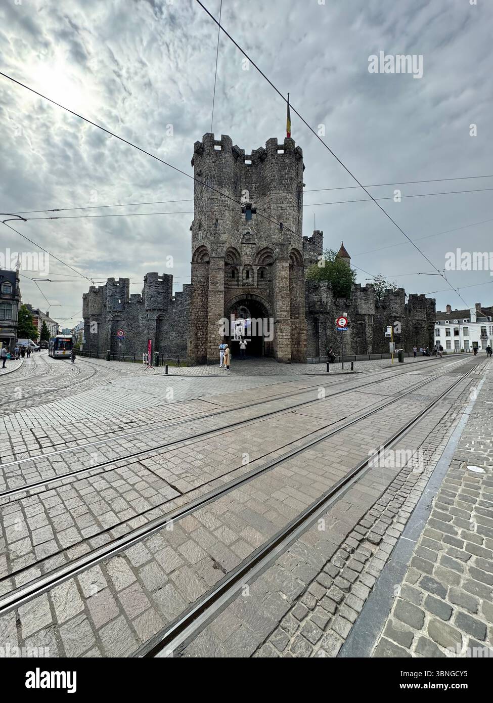 L'imposante porte du château de Gravensteen et les voies de tramway par une journée nuageuse à Gand, en Belgique. - Image de stock capturée avec un smartphone