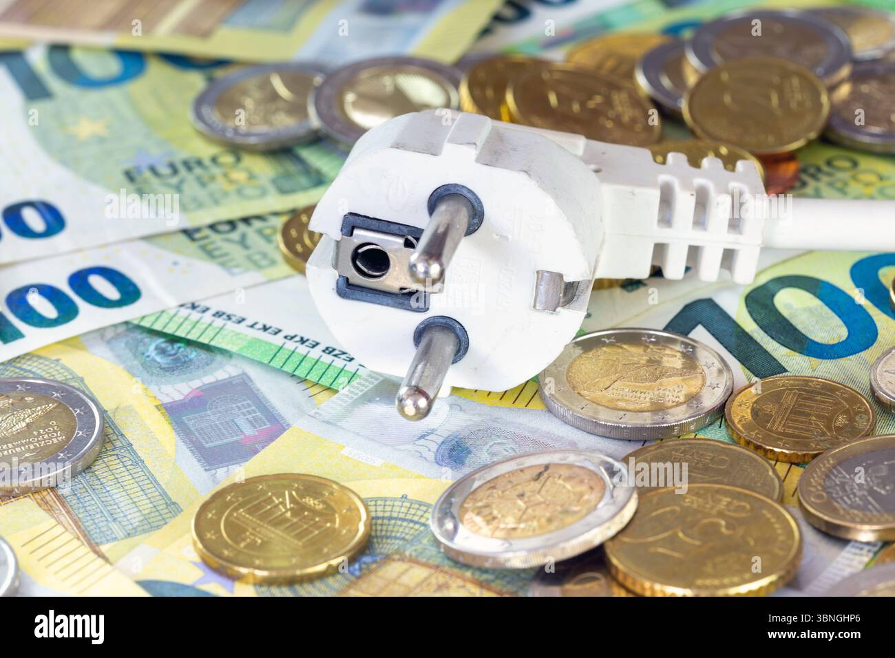 Image symbolique des coûts de l'électricité : prise de courant avec billets et pièces en euros Banque D'Images